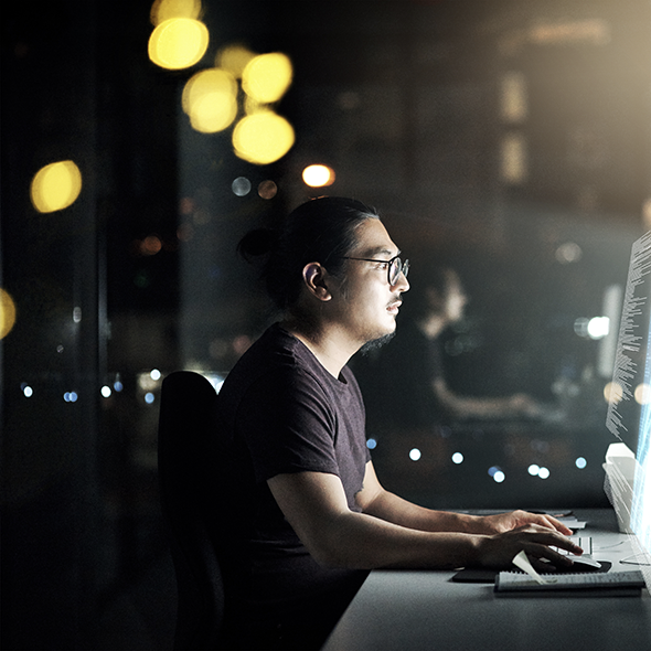 Man at desktop monitoring containers with full-stack observability via the AppDynamics Prometheus Extension