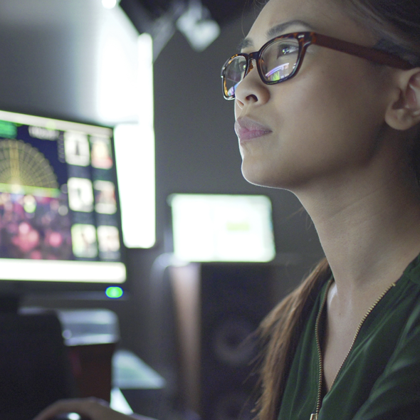 Woman with monitors monitoring a multi-cloud environment managed using Kubernetes